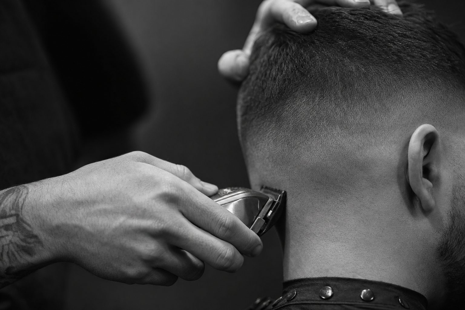 Close-up of a barber blending a clean fade with clippers